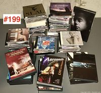 Overall view of the collection showing stacks of DVDs and CDs with visible titles including Seal, Queen On Fire, Aerosmith, and others in jewel cases and DVD cases.