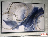 Full front view of abstract canvas wall art showing swirling blues and metallic gold circles in black frame