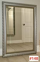 Front view of the large rectangular silver framed mirror showing beveled glass and ornate floral patterned frame.