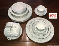 Full set layout showing the various sizes of plates stacked and six cups placed on saucers and extra saucers stacked.
