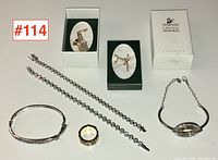 Overview of all jewellery items including two bracelets, necklace, ring, and two Swarovski boxed figurines arranged on white background with lot number tag.