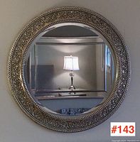 Front view of round mirror on wall showing overall design and reflection