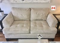 Front view showing full loveseat, tufted seats, cushion alignment and leg style