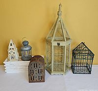 Various decorative cages in different colors, styles, and materials including metal, cast iron, and wire. Some suitable for candles or other decor.