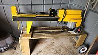 Side profile of yellow horizontal log splitter on wooden stand