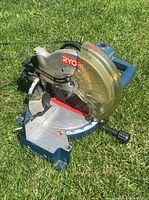 Side angle showing the saw blade, Ryobi label, handle, and yellow transparent blade guard.