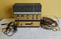 Three stacked Dynakit components with assorted cables to the right