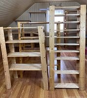 Two shelving units side by side on hardwood floor under angled ceiling