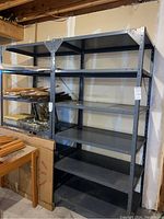 Front view of both metal shelving units side by side under basement joists