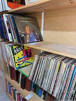 Albums on shelves, showing a large collection of vinyl records including various music genres with boxed sets.