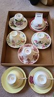 Six teacup and saucer sets in cardboard tray showing all patterns