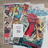 Three Marvel Spider-Man comic books together, showing front covers with visible wear and sealed in protective sleeves.