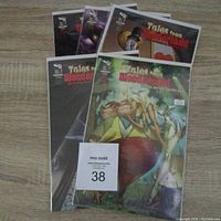 Five comic books stacked with visible cover of Tales From Wonderland showing a female character and fantasy elements.
