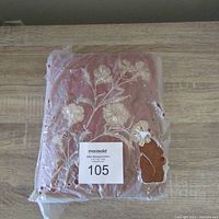 Photo of the album front cover showing red cover with floral embossing and heavy plastic lacquer damage.