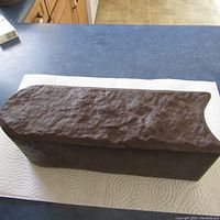 Close-up of a single brown plastic garden edging piece resting on paper towel.