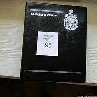 Closed black coin album titled 'CANADA 5 CENTS' with silver coat of arms