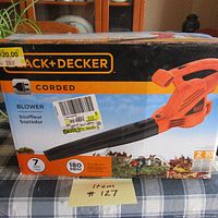 Front of box showing Black & Decker branding, corded blower image, 7 amps, 180 MPH air speed, and price stickers on box.