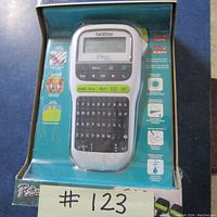 Front view of new Brother P-touch label maker in original packaging showing keyboard and display screen.