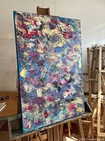 Full view of large abstract acrylic painting on an easel, showing the size and color composition.