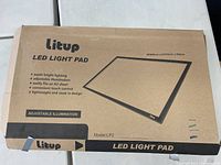 Box for the Litup LED Light Pad model LP2 detailing features including adjustable illumination, super bright lighting, lightweight and sleek design, touch control, suitable for A2 sheets.