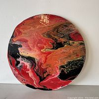 Full view of round abstract varnished dot art panel with swirling patterns in red, orange, black, and yellow tones.