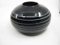 Photo of round black amethyst glass vase showing white swirl design on surface