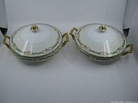Pair of Noritake Althea pattern covered vegetable serving dishes with matching lids shown from the front with handles visible.
