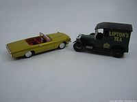 Both toy cars side by side showing scale and condition; yellow convertible and green van with branding visible