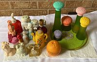 Photo showing the full Avon vintage perfume bottle collection including various decorative bottles and figurines on white paper towel.
