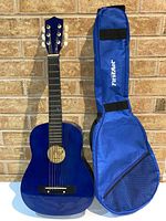 Front view of blue Burswood JF30F-B acoustic guitar next to blue soft carrying bag with FistStar branding.