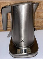Front view of the Electrolux stainless steel electric kettle on its base showing the handle, spout, and digital control buttons.