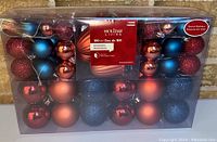 Photo of boxed set containing 100 red and blue Christmas ornaments of various finishes including shiny, matte, and glitter. All are round and shatter-resistant.