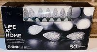 Box showing Life At Home branding, Outdoor C7 white 50 LED lights with faceted bulbs.