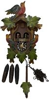 Full view of the cuckoo clock showing carved bird on top, carved leaves surrounding the clock face, three pinecone-shaped metal weights, and wooden leaf pendulum.