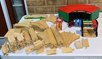 Overall collection of wooden train tracks, some curved and some straight, several junction pieces, and additional connectors.