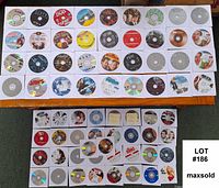 Multiple rows of 70 DVD discs laid out on a surface showing various movie titles and plain discs without cases.