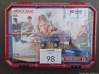 Red case of Erector by Meccano Advanced Machines Innovation Set with cover showing child building a motorized model.