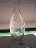 Front view of clear glass bottle embossed with 'McLaughlin's Hygeia Waters' and 'Registered Toronto'. Shows the detailed embossing and bottle condition.