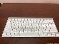 Top view showing white keys and silver aluminum frame of the Apple wireless keyboard.
