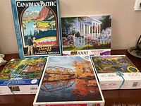 All five boxed puzzles displayed showing artwork and size labels
