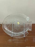 Full view of the clear pressed glass fish-shaped serving plate on stand.