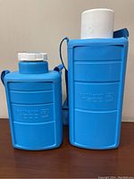 Both Camping Gaz Isotherm thermal bottles side by side, showing size difference and body embossed details.