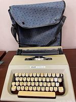 Front view of the Olivetti Lettera 30 typewriter with carry bag in background