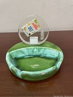 Front view of the green ceramic ashtray showing its oval shape and cigarette rests.