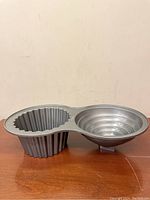 Full view of Wilton giant cupcake baking pan showing both molds: fluted cupcake base mold and stepped concentric ring mold for cupcake top.
