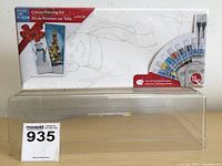 Full shot of canvas painting kit in box showing snowman and Christmas tree images and 15 paint colors included