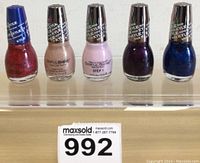 Front view of 5 Kylie Sinful Colours Signature Collection nail polish bottles in various shades, displayed in a row.