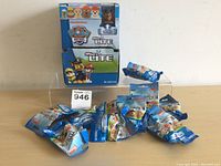 Ten sealed PAW Patrol Micro Lite pet figures and the original box shown behind.