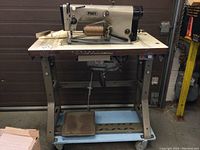 Full front view of Pfaff machine on stand showing motor base and foot pedal