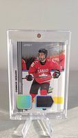 Front view of the Connor Bedard 2023-24 Upper Deck Team Canada Juniors rookie card showcasing the player's image, embedded jersey patches, and card details.